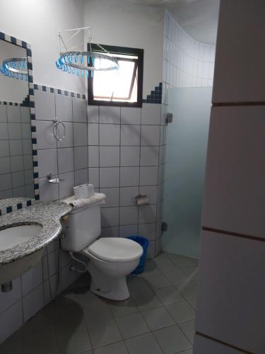 a bathroom with a toilet and a sink and a window at Recanto das Aguas Quentes in Rio Quente