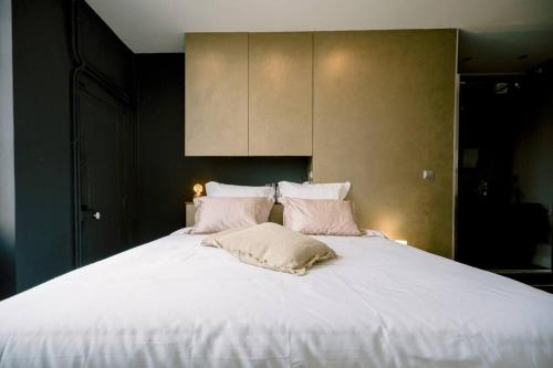 1 cama grande con sábanas y almohadas blancas en L'Oasis - Charme et confort au centre-ville en Albi