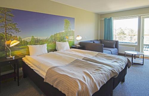ein Schlafzimmer mit einem großen Bett und einem Sofa in der Unterkunft Sotenäs Golfhotell in Hunnebostrand