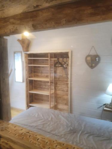 een slaapkamer met een bed en een boekenplank bij bienvenue chez les choup;s le p;tit laponie in La Bourboule
