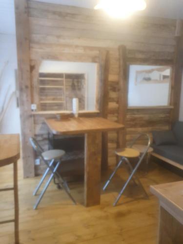 une chambre avec une table en bois et deux chaises dans l'établissement bienvenue chez les choup;s le p;tit laponie, à La Bourboule