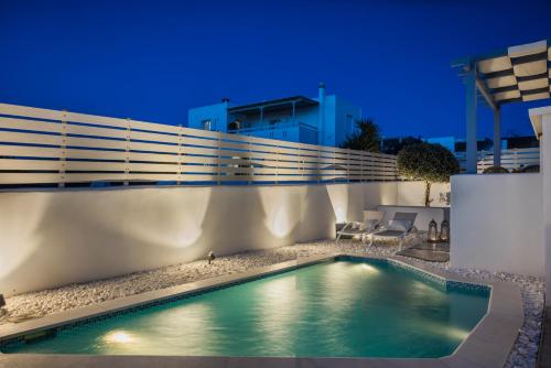 a swimming pool in front of a building at night at Pebble Summer House in Kampos Paros