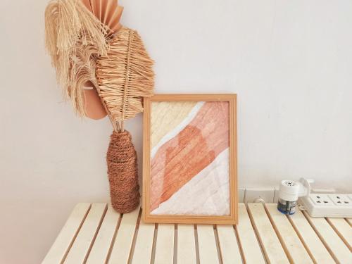 a picture frame on a table next to a painting at Boho Garden Guest House in Mirissa