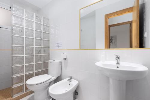 bagno bianco con servizi igienici e lavandino di Home2Book Charming Sun & Dunes Apartment a Corralejo