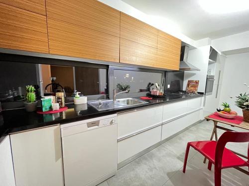 a kitchen with white cabinets and a sink and a table at Residence Kyrenia in Kérynia
