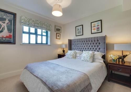 Un dormitorio con una cama grande y una ventana en 2 Hilltop Cottages en Stansted