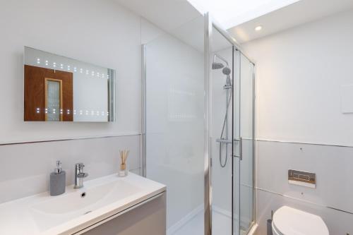 ein weißes Bad mit einem Waschbecken und einer Dusche in der Unterkunft Central, Spacious 1 Bed- Hove in Brighton & Hove