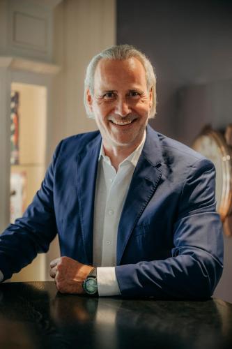 a man in a blue suit sitting at a table at Relais & Châteaux Landhaus Stricker in Tinnum
