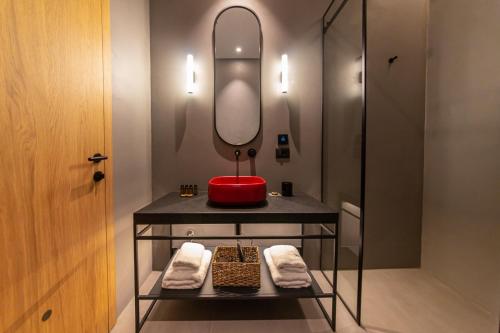 La salle de bains est pourvue d'un lavabo rouge et d'un miroir. dans l'établissement Melesin Distillery, à Leskovik