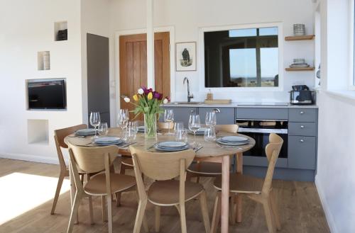 a dining room with a table and chairs and a kitchen at Coastal Eco-Lodge with hottub Charleton Estate in Elie