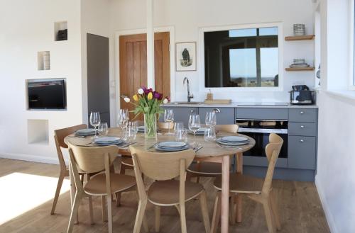 a dining room with a table and chairs and a kitchen at Coastal Eco-Lodge in Elie