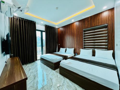 a hotel room with two beds and a television at THÀNH HỒNG HOTEL in Ha Tinh