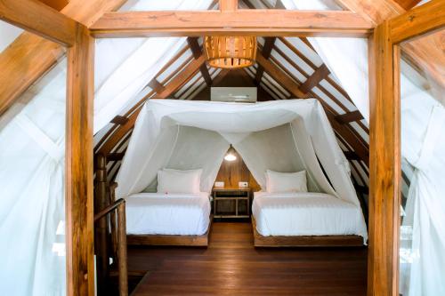 een slaapkamer met 2 bedden op een zolder bij Island View Bar & Bungalow in Gili Air