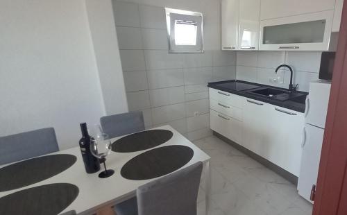 een keuken met een tafel met stoelen en een wastafel bij Apartment Bougainvillea in Trogir