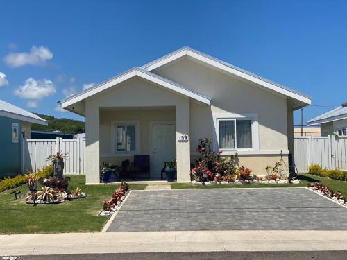 a small house with a white fence at Serenity Get Away in Lucea