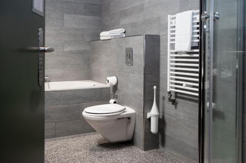 a bathroom with a toilet and a bath tub at Leerhotel Het Klooster in Amersfoort