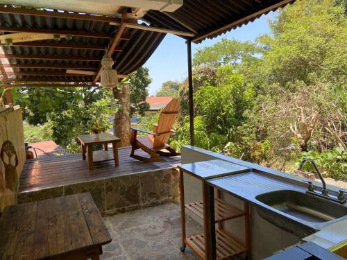 a kitchen with a deck with a sink and a table at Colibri hostal Minca Santa Marta in Minca