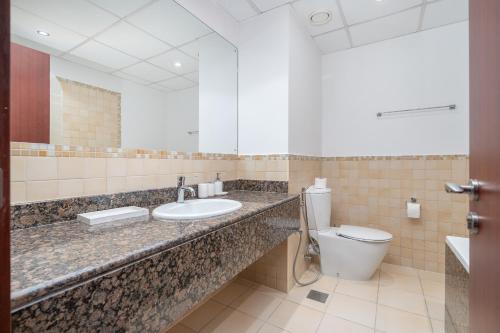 a bathroom with a sink and a toilet at JBR Beach Bliss - One & Three Bedroom Luxury Apartments by Sojo Stay in Dubai
