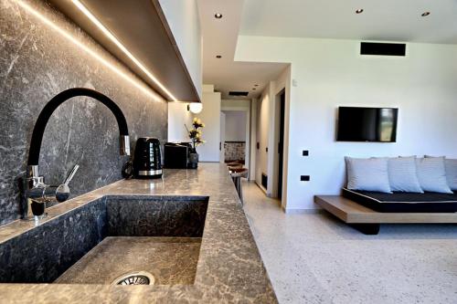 een badkamer met een wastafel en een bank in een kamer bij ELMARAL living experience "Adults Only" in Agia Pelagia