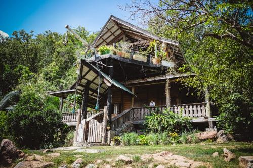 a wooden house with a balcony in the woods at Secret Villa in La Digue