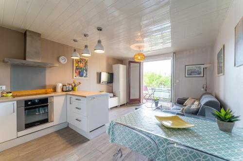 une cuisine et un salon avec une table et un canapé dans l'établissement Le Mesnil - 200m des plages, à Arcachon
