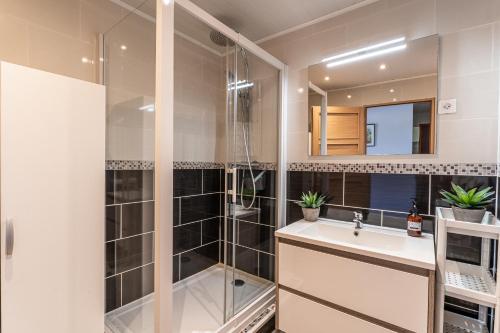 a bathroom with a shower and a sink and a mirror at Le Mesnil - 200m des plages in Arcachon