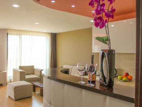 eine Küche mit einer Theke mit Weingläsern und einer Vase mit Blumen in der Unterkunft Hotel Dream in Sofia