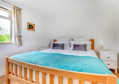 een slaapkamer met een groot bed en een blauwe deken bij Broomhurst Grove in Mayfield