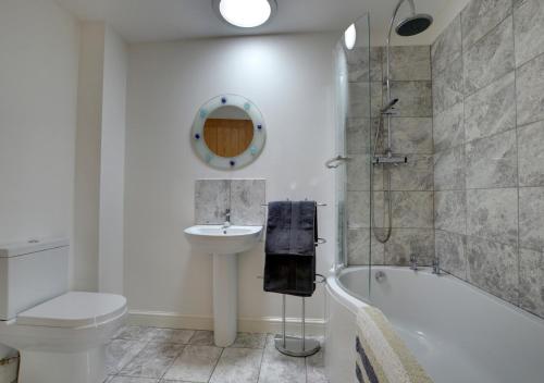 a bathroom with a sink and a toilet and a bath tub at Broomhurst Grove in Mayfield