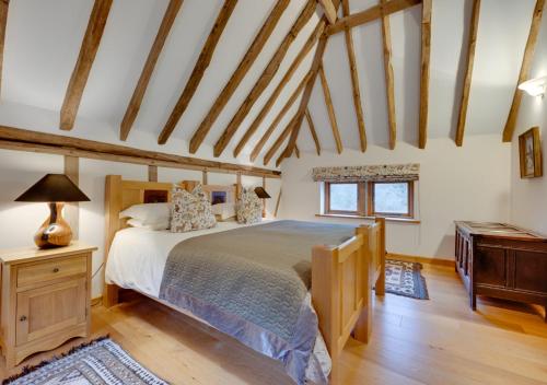 a bedroom with a large bed and a wooden floor at Birdsong Barn in Westfield