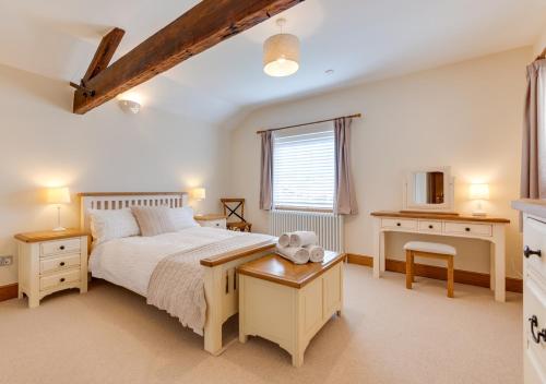 a bedroom with a bed and a desk and a window at Chapel House in Sandwich