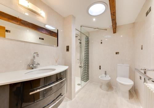 a bathroom with a sink and a toilet and a shower at Chapel House in Sandwich