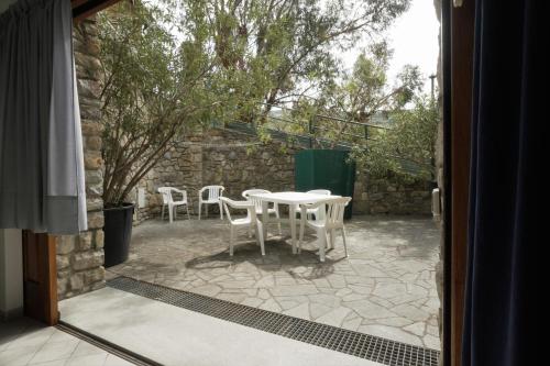 a patio with a table and chairs outside a door at U Ciousu by Ligurian Life APPARTAMENTI IN AGRITURISMO in Vallebona