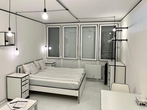 a bedroom with a bed and some windows at 2D Apartment in Szekszárd