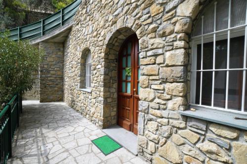 a stone building with a wooden door and a window at U Ciousu by Ligurian Life APPARTAMENTI IN AGRITURISMO in Vallebona