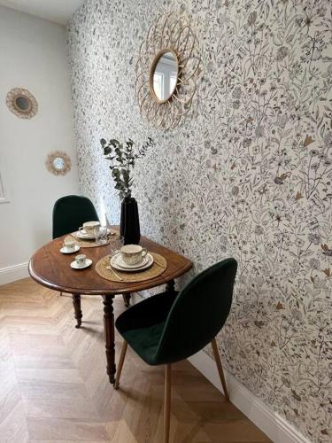 une salle à manger avec une table, des chaises et un miroir dans l'établissement Studio Patchouli - Centre historique de Grasse, musées, boutiques, à Grasse
