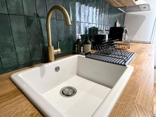 a white sink in a kitchen with a faucet at Studio Patchouli - Centre historique - Climatisation - WiFi in Grasse