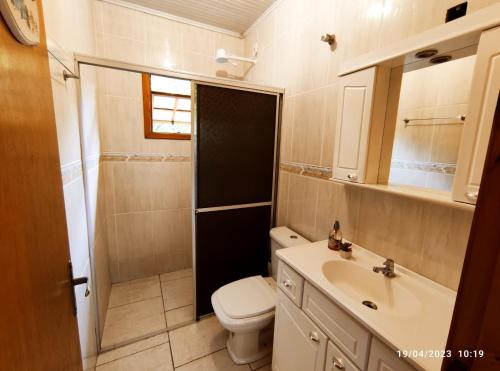 a small bathroom with a toilet and a sink at Casa de campo com acesso ao Rio in Encantado