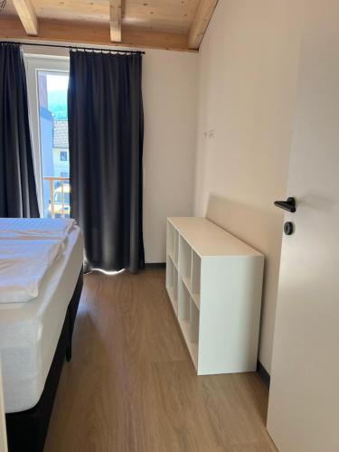 een slaapkamer met een bed, een bureau en een raam bij Apartmán Michal in Rattendorf
