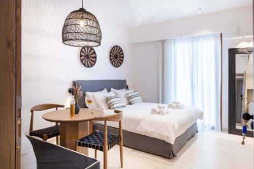 Un dormitorio con una cama y una mesa y sillas. en ELMARAL living experience "Adults Only", en Agia Pelagia