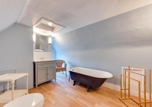 a bathroom with a tub and a toilet and a sink at Church Cottage in Barham