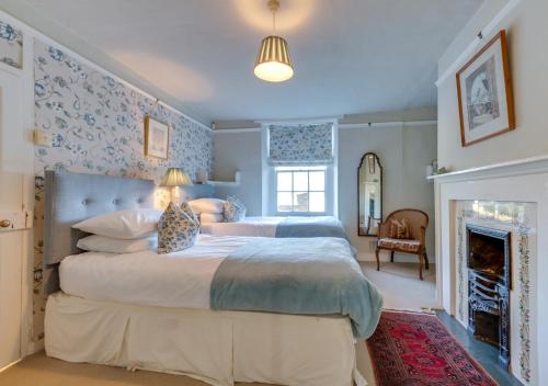 a bedroom with a large bed and a fireplace at Church Cottage in Barham