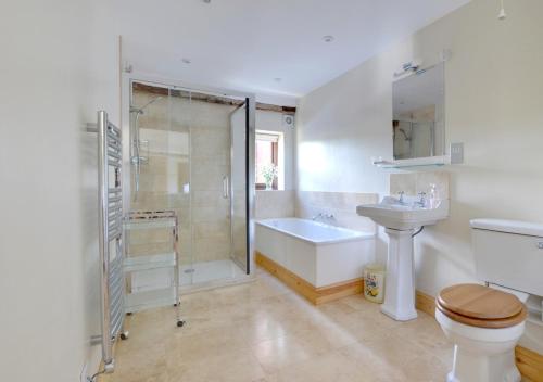 a bathroom with a shower and a toilet and a sink at Dairy Cottage in Wadhurst