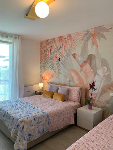 ein Schlafzimmer mit einem Bett mit einem tropischen Wandbild in der Unterkunft Casanova Sirmione in Sirmione