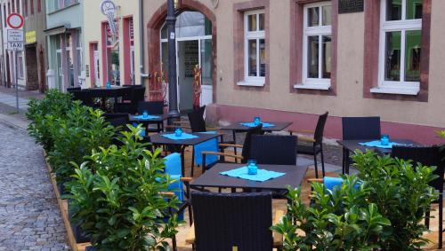 an outdoor cafe with tables and chairs on a street at Hotel Goldener Löwe in Waldheim