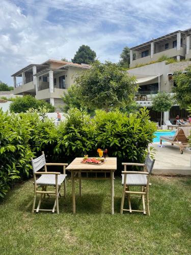 a table and chairs in the grass near a pool at Crystal Waters in Nikiana