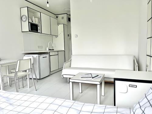 cocina con sofá, mesa y sillas en 2D Apartment, en Szekszárd