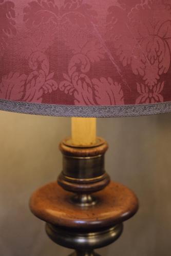 a wooden table with a lamp on top of it at Foresteria Palazzo Guazzoni Zaccaria in Cremona
