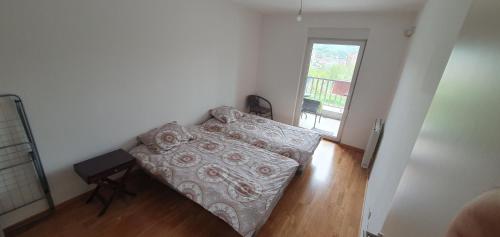 a small bedroom with a bed and a window at Modern Apartment in Zenica in Zenica