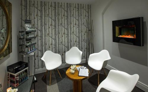 a therapy room with three white chairs and a table at Ferrycarrig Hotel in Wexford